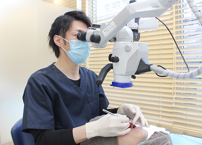 TOSHI DENTAL CLINIC 武蔵野市 治療を行う歯科医師の写真
